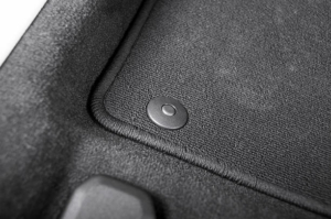 Corner of car mat with floor holder in white car interior